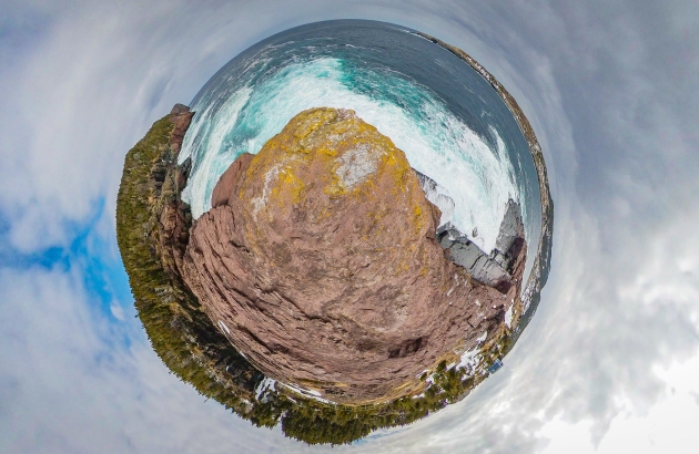 A lookout point in Flatrock, NL. Brown rock formation in water.